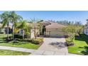 Charming single-story home featuring a well-manicured lawn and an attached two-car garage with a brick-paved driveway at 2468 Coco Palm Cir, Wesley Chapel, FL 33543