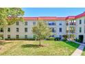 Well-maintained building with a vibrant red roof, surrounded by lush landscaping and a green lawn at 2700 Bayshore Blvd # 4204, Dunedin, FL 34698
