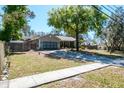 Exterior view of a well-maintained home with a two-car garage and a spacious front yard at 275 S Highland Ave, Tarpon Springs, FL 34689