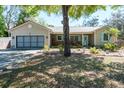 Inviting single-story home with a cozy front porch, shutters, and beautiful landscaping at 275 S Highland Ave, Tarpon Springs, FL 34689