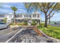 Townhome exterior featuring grey stucco, lush landscaping, and convenient parking at 297 Countryside Key Blvd, Oldsmar, FL 34677