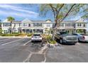 Townhome exterior showcasing grey stucco facade, ample parking, and mature landscaping at 297 Countryside Key Blvd, Oldsmar, FL 34677