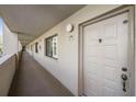 Hallway featuring unit door, neutral paint, and outdoor access at 3076 Eastland Blvd # 305, Clearwater, FL 33761