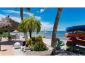 Picturesque beach area with palm trees, kayaks, and a tiki hut, providing a tranquil waterfront setting at 3735 42Nd S Way # J, St Petersburg, FL 33711