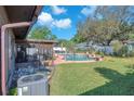 A backyard featuring a refreshing swimming pool, screened patio, and a well-maintained lawn at 808 Centerwood Ct, Brandon, FL 33511