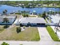 Aerial view of a single-story home with a spacious yard, covered parking, and waterfront access at 810 Blue Heron Blvd, Ruskin, FL 33570