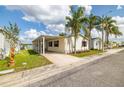 Charming single-story home with carport, lush lawn, and mature palm trees under a sunny blue sky at 8632 Fantasia Park Way, Riverview, FL 33578