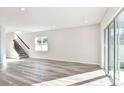 Spacious living room with gray wood floors, a staircase and a window offering natural light at 9764 Crescent Moon Dr, Riverview, FL 33578