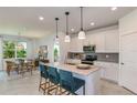 A kitchen featuring a center island with pendant lighting, granite countertops, and white cabinetry at 9816 Crescent Moon Dr, Riverview, FL 33578
