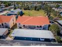 Aerial view of condo buildings with red roofs and covered parking at 9980 Eagles Point Cir # 1, Port Richey, FL 34668
