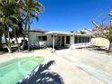Backyard featuring a patio area, small pool, and lush palm trees at 121 175Th E Ave, Redington Shores, FL 33708