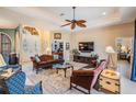 Cozy living room with a decorative ceiling fan, neutral walls, and large windows at 13514 Thoroughbred Dr, Dade City, FL 33525