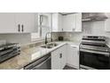 Bright kitchen featuring stainless steel appliances, white cabinets and granite countertops at 170 E Davis Blvd, Tampa, FL 33606
