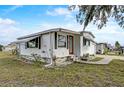 A cozy single-story home boasting a manicured lawn, red front door, and charming curb appeal at 1710 7Th Sw St # 95, Ruskin, FL 33570