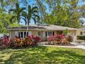 Charming single-story home featuring lush landscaping, palm trees, and a welcoming front porch at 1808 Gray S St, Gulfport, FL 33707