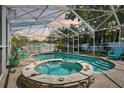 Screened-in pool with attached hot tub surrounded by brick pavers at 1808 Gray S St, Gulfport, FL 33707