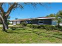 Home exterior with an attached two-car garage and mature landscaping at 1828 Stancel Dr, Clearwater, FL 33764