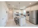 Modern kitchen featuring an island, stainless steel appliances, and bright white cabinets at 19212 Iron Topsail Isle, Land O Lakes, FL 34638