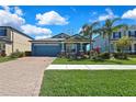 Inviting single-story home featuring a brick driveway and lush landscaping at 19793 Long Lake Ranch Blvd, Lutz, FL 33558