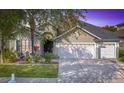 Charming home featuring a well-manicured lawn, mature tree, and a three car garage at 2327 Shirecrest Cove Way, Lutz, FL 33558