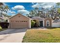 Single-story home featuring an attached two-car garage and a freshly cut lawn at 2329 Towering Oaks Cir, Seffner, FL 33584
