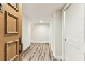 Bright hallway featuring wood-look floors and white walls with a wooden door at 36750 Us 19 N # 08102, Palm Harbor, FL 34684