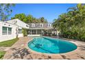 Beautiful pool area with lush landscaping, patio, and a screened-in porch at 4506 W Beachway Dr, Tampa, FL 33609