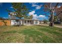 Landscaped front yard with a well-maintained lawn and mature trees surrounding this charming home at 5411 96Th N Ter, Pinellas Park, FL 33782