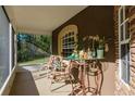 Cozy screened porch with outdoor seating, plants, and natural light streaming in from the surrounding landscape at 7182 Griffin Rd, Brooksville, FL 34601