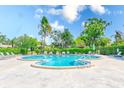 Community swimming pool features a unique shape with plenty of lounge chairs and greenery at 8066 Brentwood Rd # 8066, Seminole, FL 33777