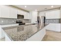 Modern kitchen with granite countertops, stainless steel appliances, and a center island with a sink at 9832 Crescent Moon Dr, Riverview, FL 33578