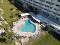 Resort-style condo swimming pool with lounge chairs and lush tropical landscaping at 100 Bluff View Dr # 502C, Belleair Bluffs, FL 33770