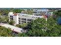 Aerial view of condo building surrounded by lush trees and water feature at 11485 Oakhurst Rd # A202, Largo, FL 33774