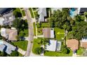 Aerial view of a home with a well-maintained lawn, mature trees, a driveway, and neighboring houses at 1836 Bayou Grande Ne Blvd, St Petersburg, FL 33703