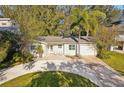 Inviting one-story home with well-manicured lawn, ample parking, and a cozy entrance with seating at 1908 Sutherland W Dr, Palm Harbor, FL 34683