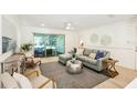 Bright living room with modern decor, a comfortable sofa, and sliding glass doors to the outdoor patio at 1908 Sutherland W Dr, Palm Harbor, FL 34683