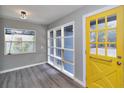 Light-filled entryway with gray walls, modern flooring, and a distinctive yellow front door at 201 83Rd N Ave, St Petersburg, FL 33702