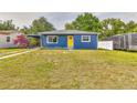 Lovely single-story home featuring blue siding, a bright yellow door, and a convenient carport at 201 83Rd N Ave, St Petersburg, FL 33702