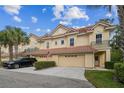 Inviting townhome featuring a red tile roof, well-manicured lawn, and ample parking with mature trees at 2676 Tanglewood Trl, Palm Harbor, FL 34685