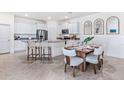 Stylish kitchen and dining area with white cabinets, stainless steel appliances, and a breakfast bar at 3701 Stormy Thistle Pl, Plant City, FL 33565