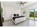 Bright bedroom with a ceiling fan, white walls, gray flooring and a sliding door to the backyard at 4036 56Th N Ave, St Petersburg, FL 33714