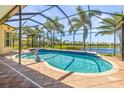 Screened-in pool with a dolphin statue, brick tile, and view of the lake at 5073 Stone Harbor Cir, Wimauma, FL 33598