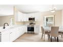 Well-lit kitchen boasting white cabinets, stainless steel appliances, and an adjacent dining area at 5105 Gato Del Sol Cir, Wesley Chapel, FL 33544