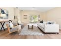 Bright living room with vaulted ceilings, wood-look floors, neutral paint, and modern furniture at 5105 Gato Del Sol Cir, Wesley Chapel, FL 33544