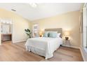 Bright primary bedroom featuring wood-look floors, a light color palette, and ensuite bathroom at 5105 Gato Del Sol Cir, Wesley Chapel, FL 33544
