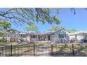 Charming single-story home with a pergola-covered front porch and a black metal fence surrounding the property at 515 34Th Ne Ave, St Petersburg, FL 33704
