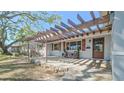 Inviting front porch featuring a pergola, stone accents, seating, and a stylish front door with glass inserts at 515 34Th Ne Ave, St Petersburg, FL 33704