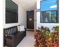 Inviting front porch with bench, colorful plants, and stylish decor for a welcoming entrance at 523 Bayport Way # 523, Longboat Key, FL 34228
