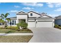 Elegant two-story home showcasing a well-maintained lawn, tasteful landscaping, and a two-car garage at 5402 Limelight Dr, Apollo Beach, FL 33572