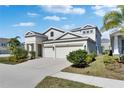 Charming two-story home featuring a paved driveway, well-kept lawn, and a spacious two-car garage at 5402 Limelight Dr, Apollo Beach, FL 33572